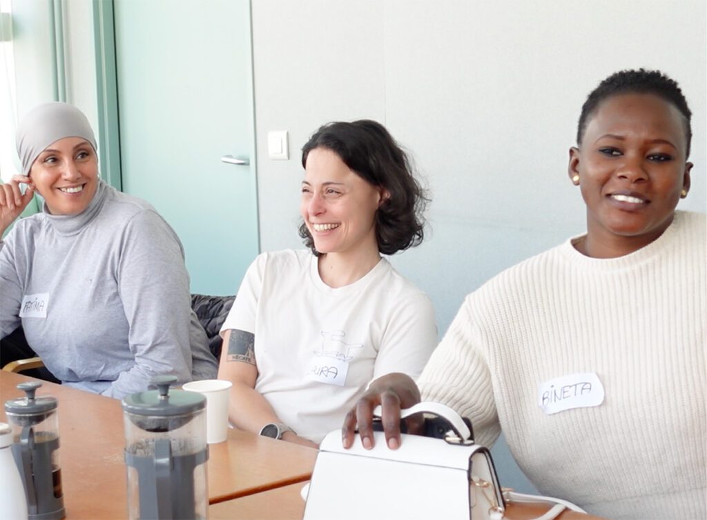 Trois femmes assises à une table souriantes
