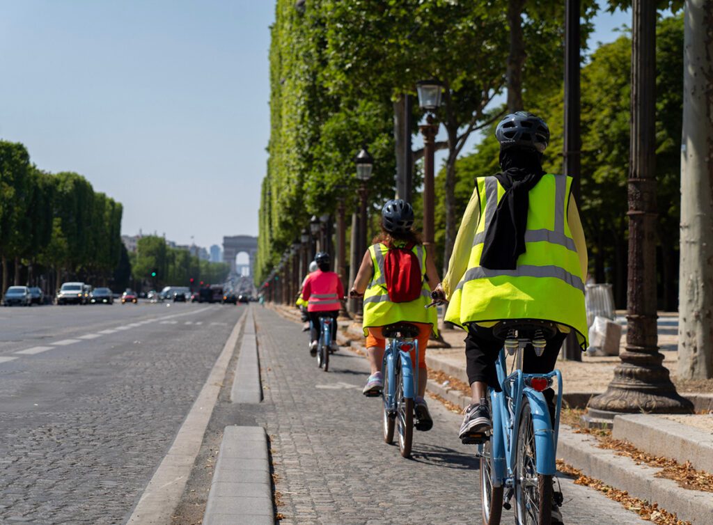 Des femmes à vélo remontent les Champs-Elysées