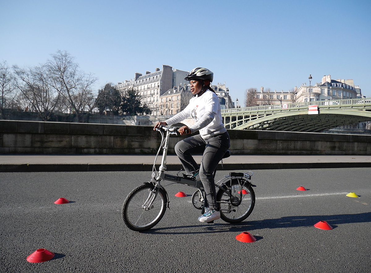 Une apprenante sur un vélo pliant