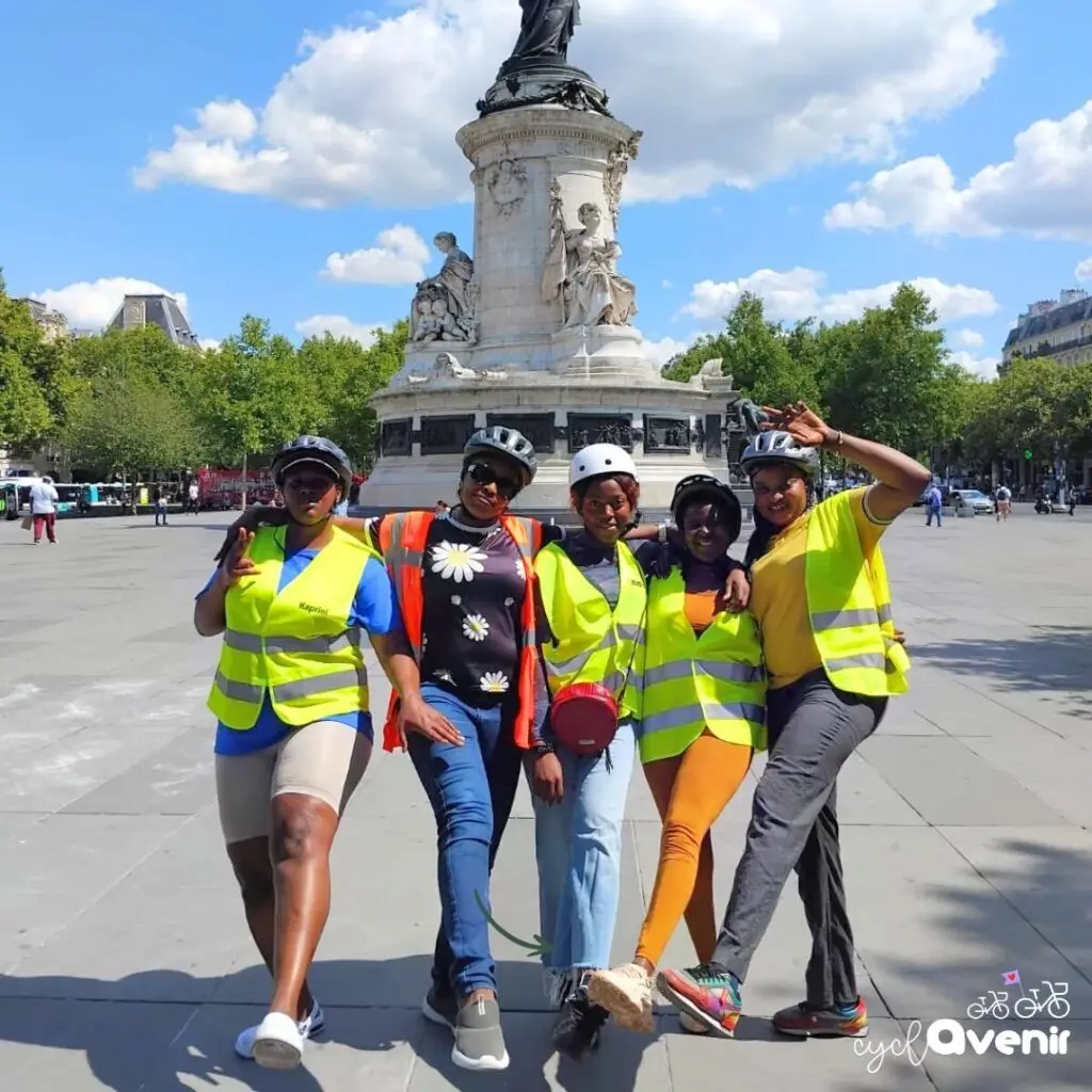 Groupe de femmes avec gilet de vélo qui posent devant la Bastille.